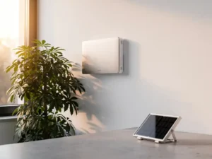 PCM-koelpaneel op witte muur naast groene plant, zonnepaneel op betonnen oppervlak, warm natuurlijk daglicht.