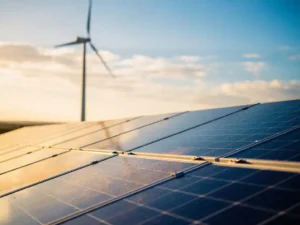 Zonnepanelen op zonnig dak naast moderne windturbine tijdens gouden uur, kobaltblauwe cellen contrasteren met warm amberkleurig licht.